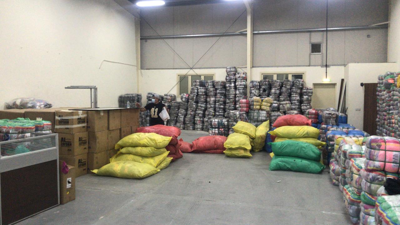 Team sorting fresh imported bales and colour-coded sacks on the Manila Fashion warehouse sorting floor