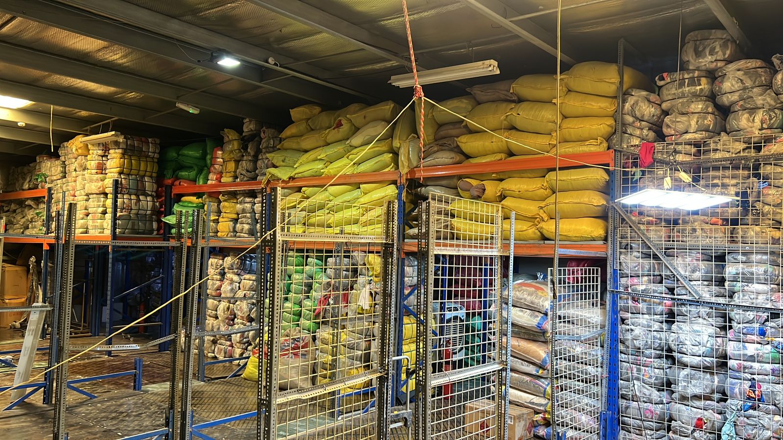 Industrial warehouse racks stacked high with packed wholesale clothing bales in Dubai
